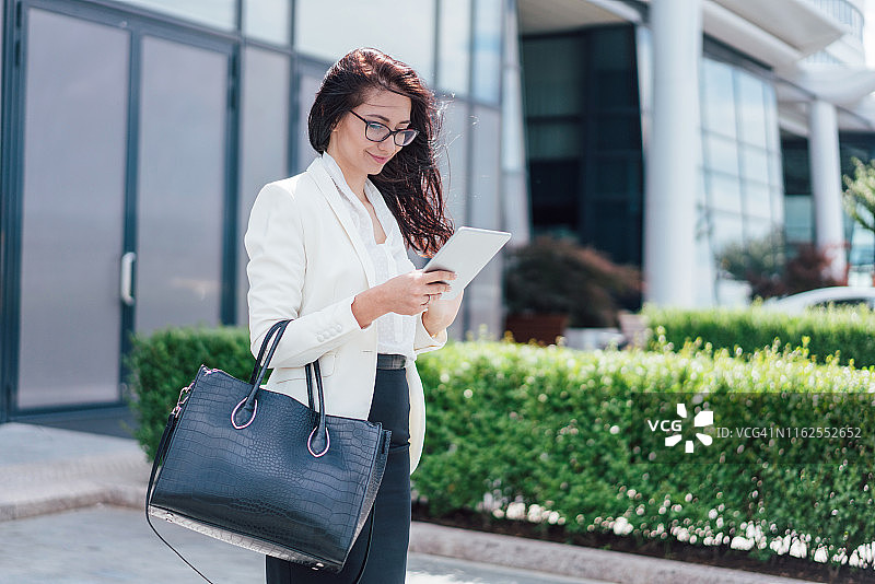 在平板电脑上浏览的迷人女商人图片素材