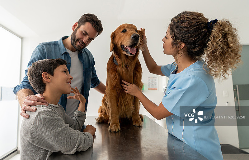 快乐的父子带狗去看兽医图片素材