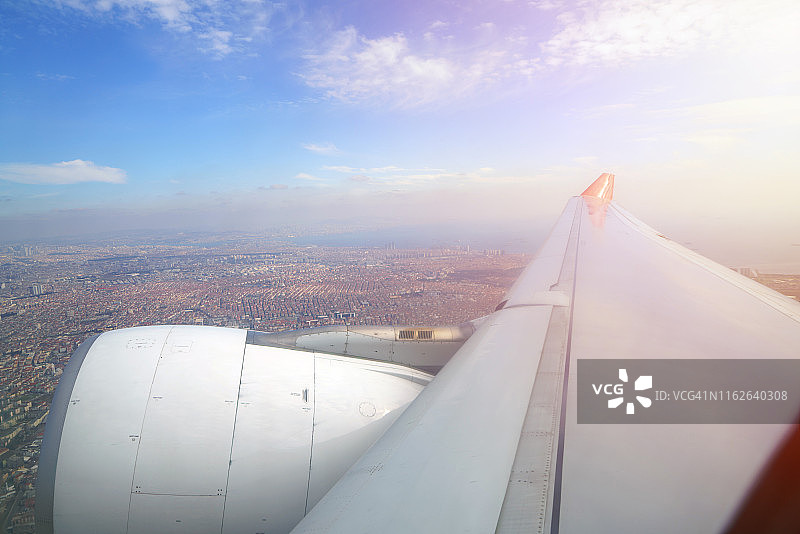 日出时分飞行的飞机机翼特写图片素材