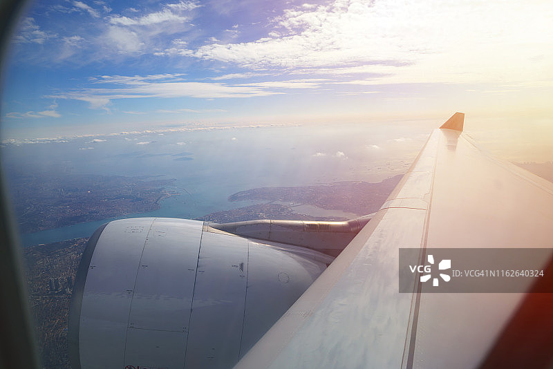 日出时分飞行的飞机机翼特写图片素材