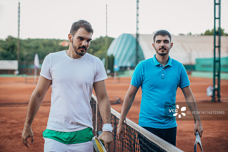 球场上球网旁的年轻网球运动员图片素材