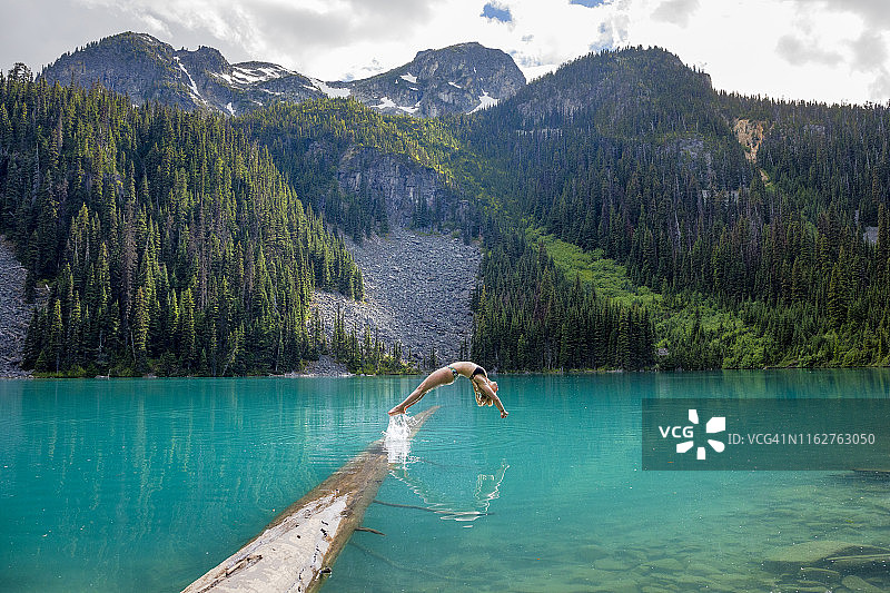 女孩完美地向后潜入乔弗雷湖的蓝色水域图片素材