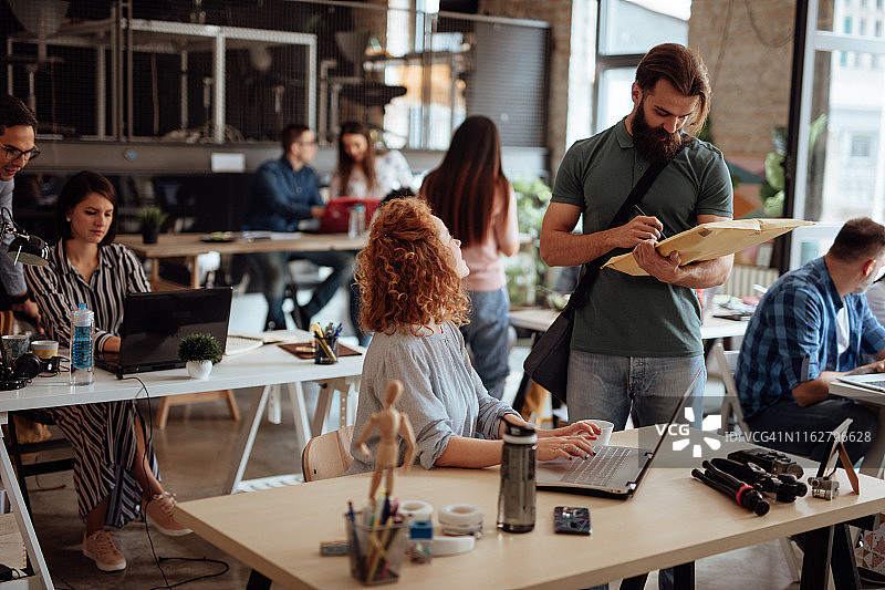 女人从送货员手中接过包裹图片素材