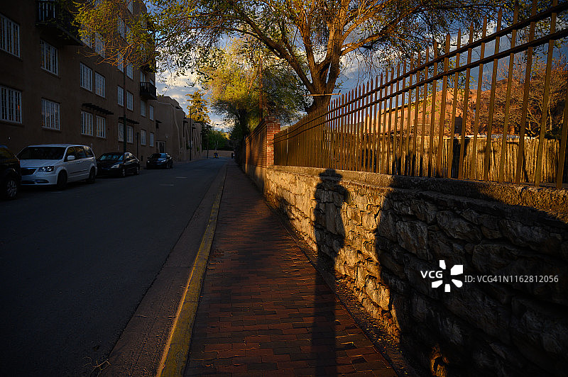 在圣菲日落时分戴牛仔帽的人的长阴影图片素材
