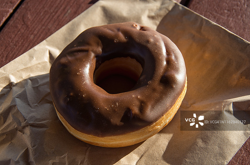 棕色纸袋上的巧克力甜甜圈图片素材