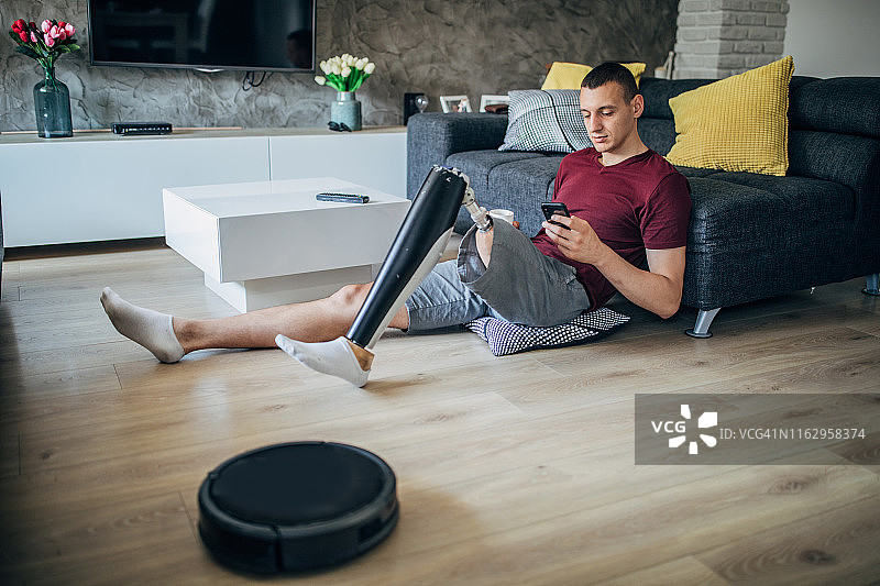 残疾男子坐在客厅地板上图片素材