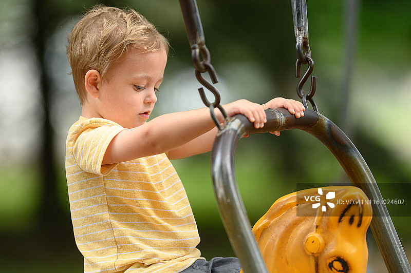 3岁幼儿专心攀爬游乐场设施图片素材