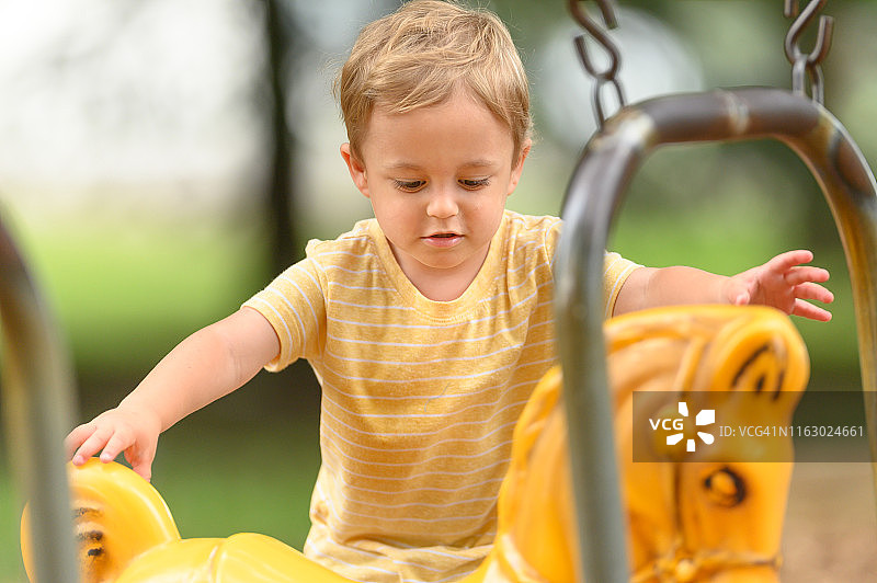 3岁幼儿专心攀爬游乐场设施图片素材