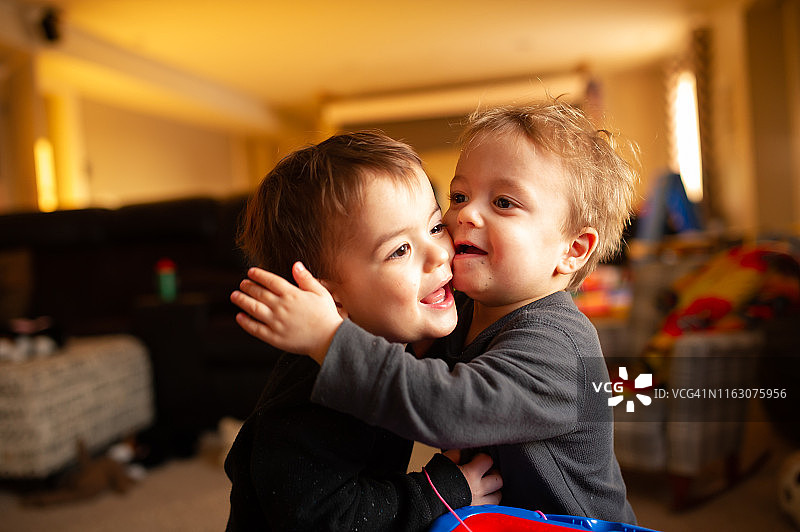 玩耍时拥抱在一起的幼儿双胞胎图片素材