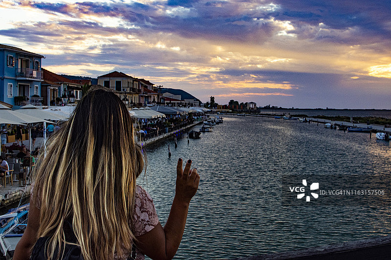 美丽的女孩与希腊莱夫卡达日落图片素材