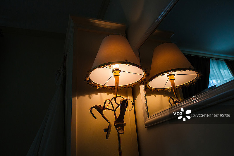 新娘的鞋子挂在酒店房间的灯罩下图片素材