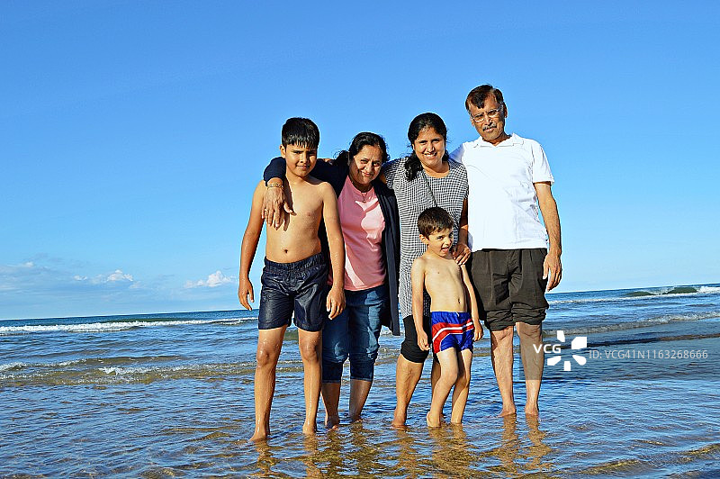 一家五口在海滩上心情愉快地随意摆姿势图片素材