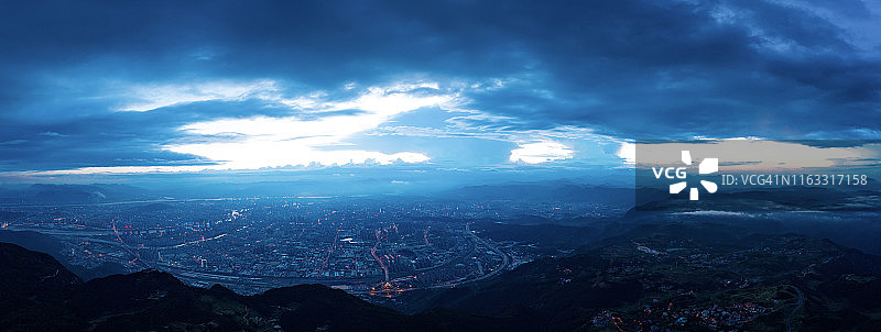 日落时分，山麓之外的城市航拍，天空云彩壮丽图片素材
