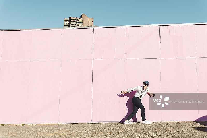 在粉红色施工屏障前试图逃脱的年轻男人图片素材