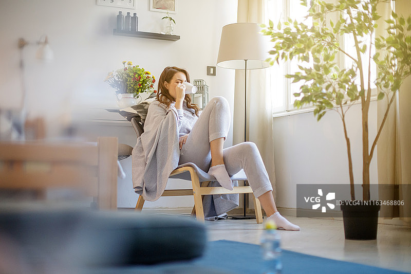 坐在扶手椅上享受早晨咖啡的女人图片素材