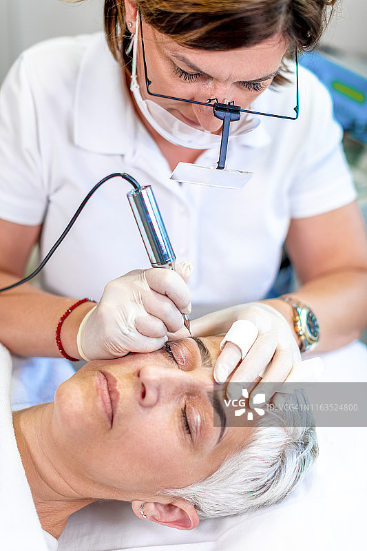 美容师在美容院为女士纹眉图片素材