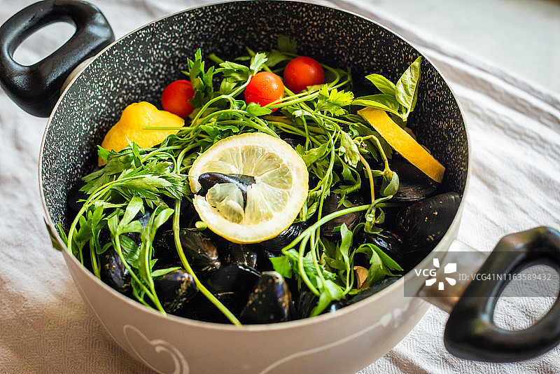 准备烹饪的贻贝、欧芹、柠檬和樱桃番茄图片素材