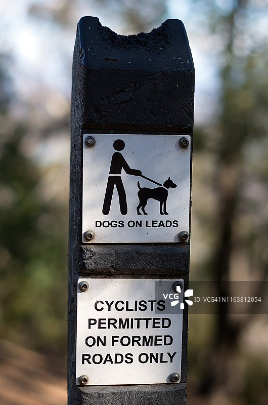 澳大利亚堪培拉安斯利山自然保护区小径指示牌：禁止狗进入和自行车通行图片素材