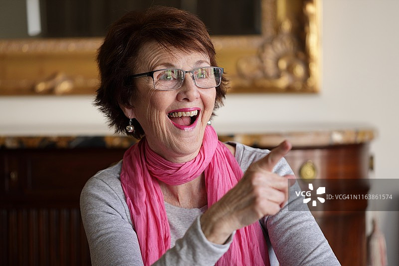 面带微笑，快乐的老年人指着某人图片素材