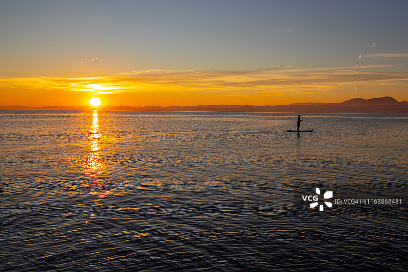 加尔达湖日落时分的桨板运动图片素材
