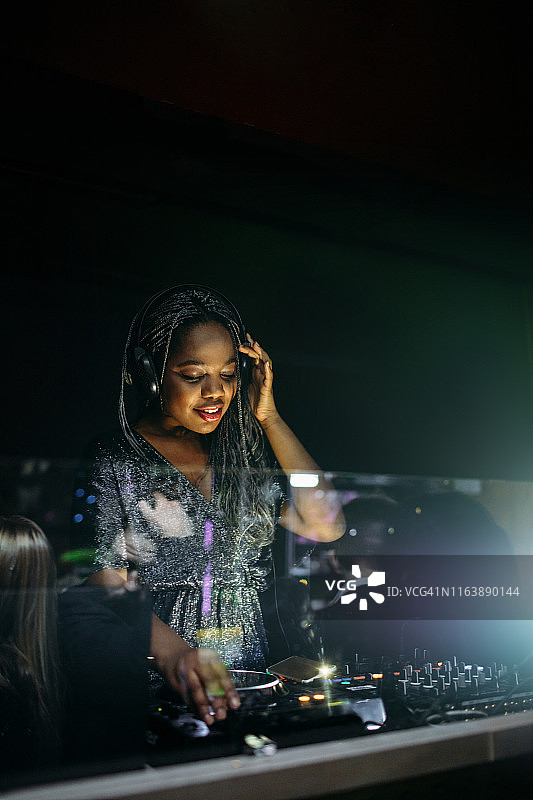 在聚会上夜总会里美丽的年轻非洲DJ图片素材