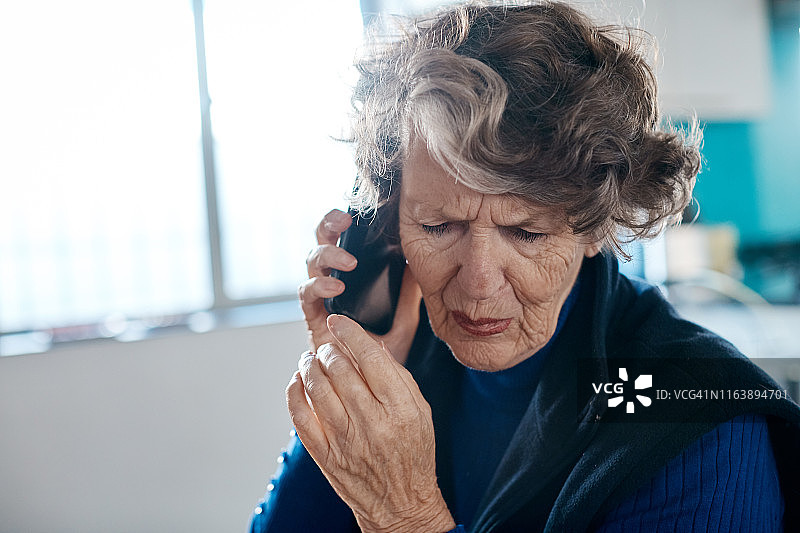不高兴的老年妇女使用手机图片素材