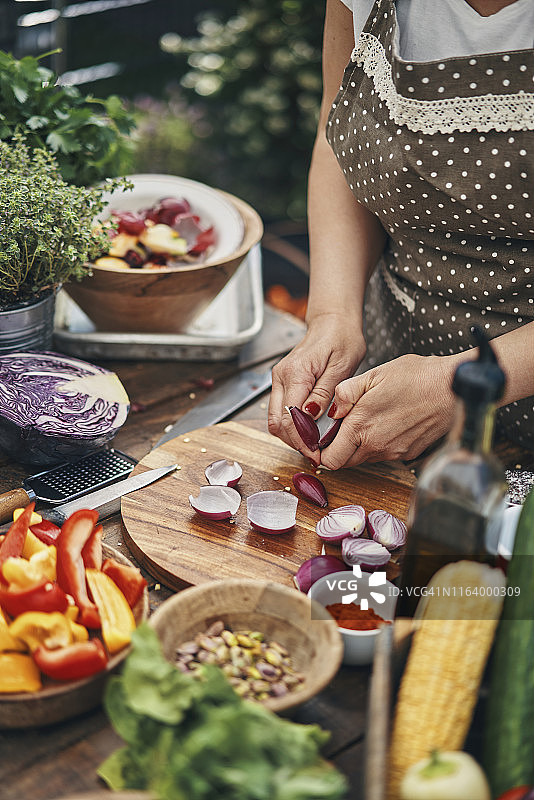 年轻家庭在户外用蔬菜、香草和香料烹饪图片素材