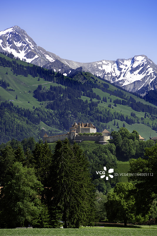瑞士格吕耶尔地区乡村的中世纪山顶城堡，背景是阿尔卑斯山。图片素材
