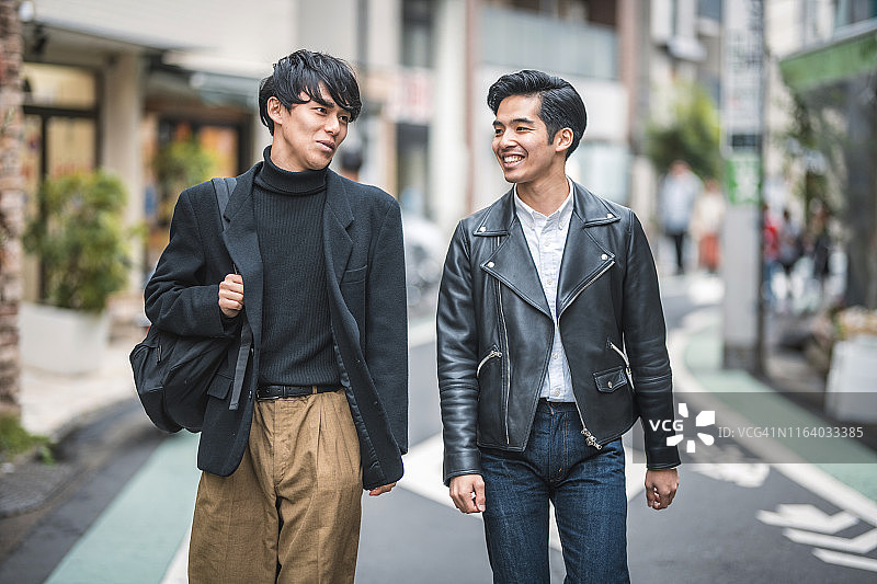 在东京街头漫步交谈的年轻休闲日本男人图片素材