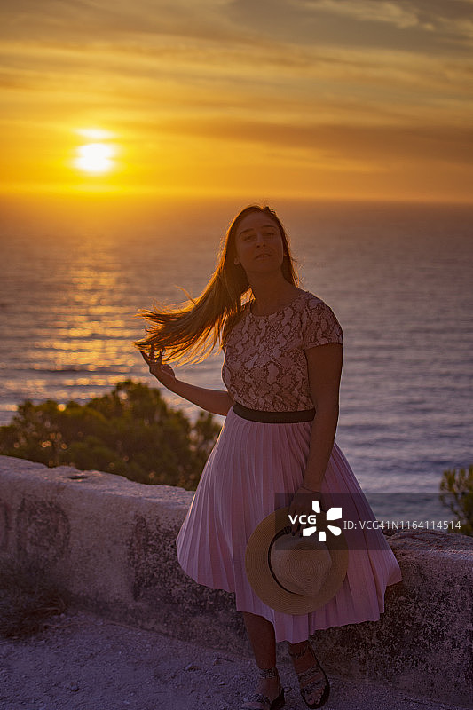 在希腊莱夫卡达“壮丽日落景观”处的美丽女孩图片素材