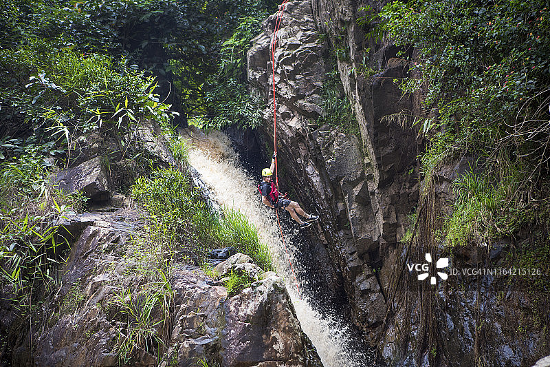 男人在大叻达坦拉瀑布速降图片素材