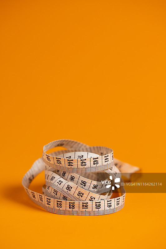 橙色背景上的尺寸测量仪图片素材