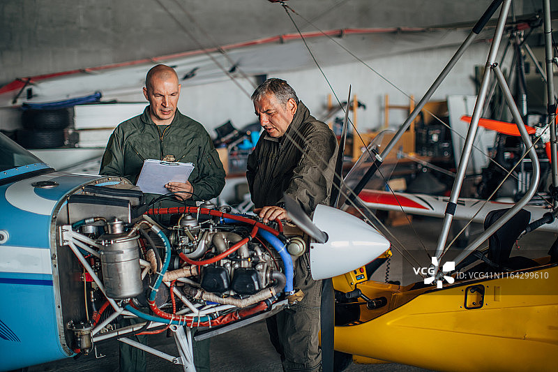机械师一起修理螺旋桨飞机引擎图片素材