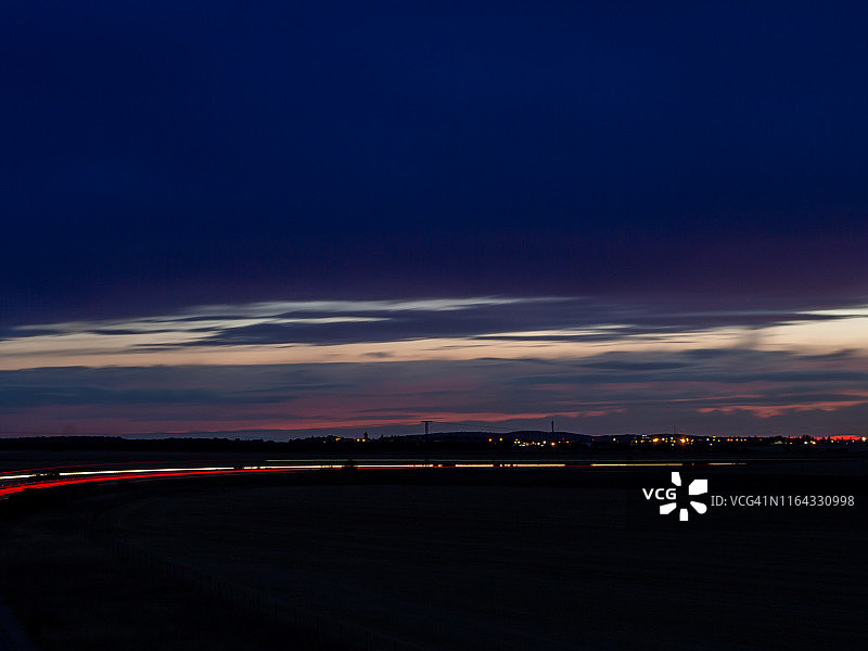 黄昏弯道行驶的车辆灯光轨迹图片素材