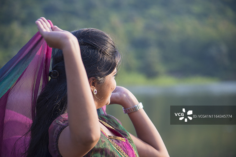 快乐的印度女孩在户外玩粉色围巾图片素材