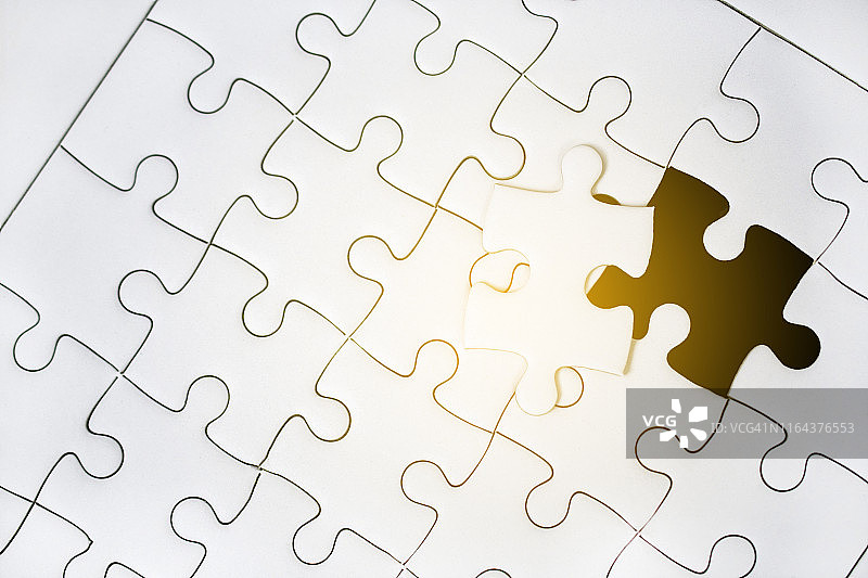 在黑色背景上放入最后一块拼图以完成任务或业务目标图片素材