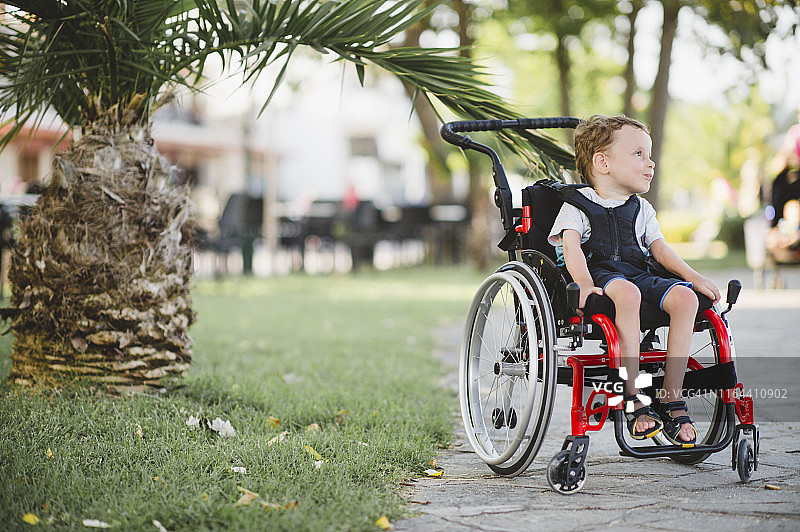 坐在轮椅上的可爱残疾男孩图片素材