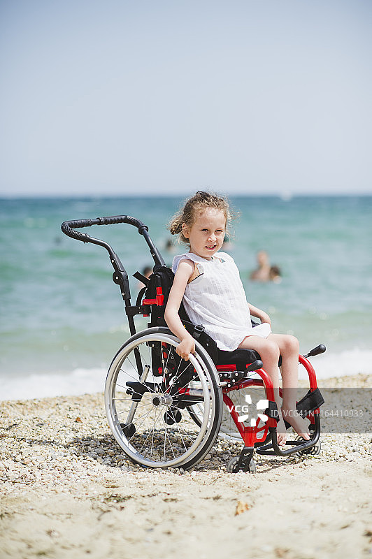 坐在海边轮椅上的可爱小女孩图片素材