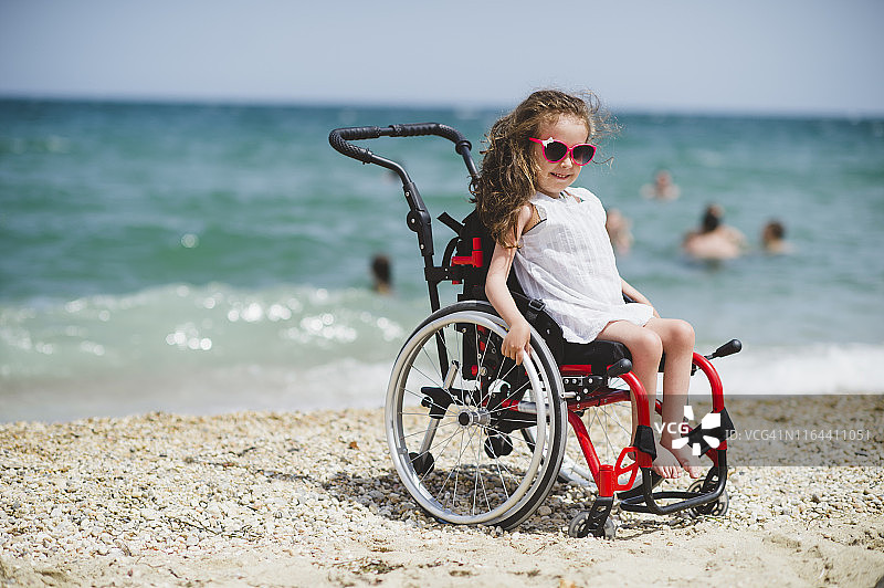 坐在海边轮椅上的可爱小女孩图片素材