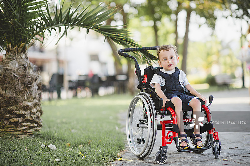 坐在轮椅上的可爱残疾男孩图片素材