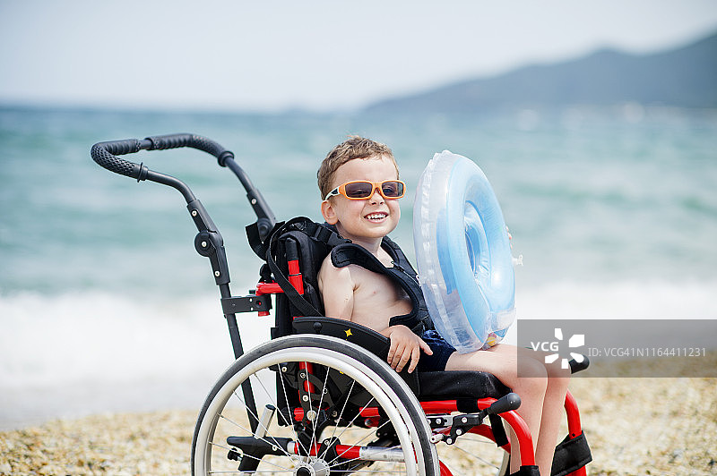 坐轮椅的可爱男孩去游泳图片素材