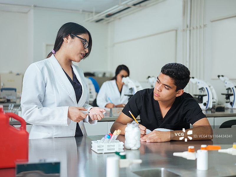 实验室学生在实验室里拿着样本并做笔记图片素材