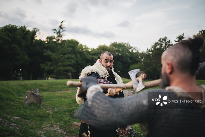 两个中世纪的男人在户外用斧头战斗图片素材