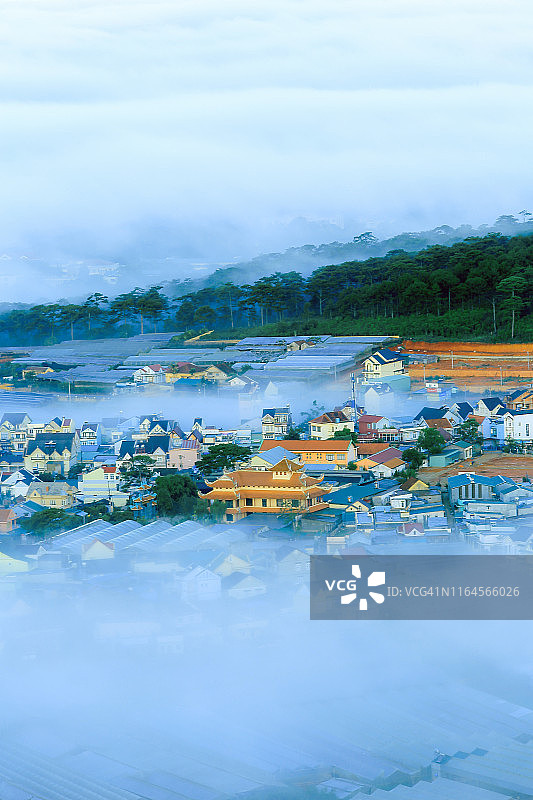 雾中城市璀璨房屋与日出魔幻光线图片素材