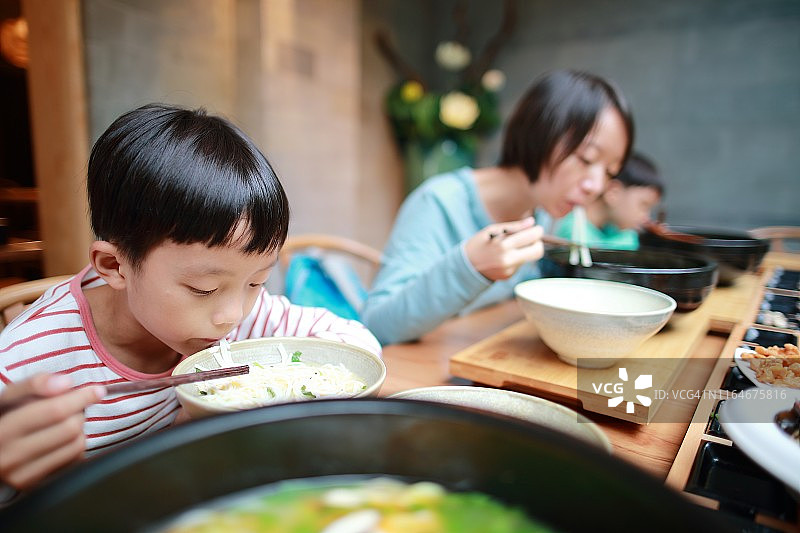 男孩用筷子吃米粉图片素材