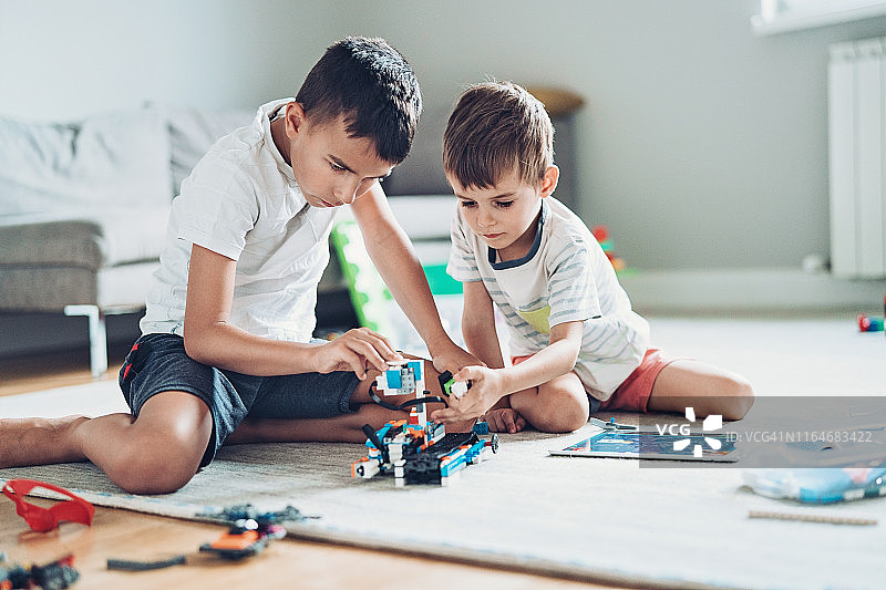 两个男孩用零件组装机器人图片素材