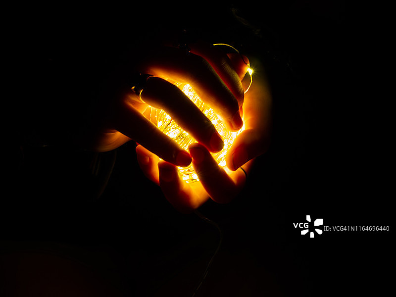 照亮女人双手的童话灯光图片素材