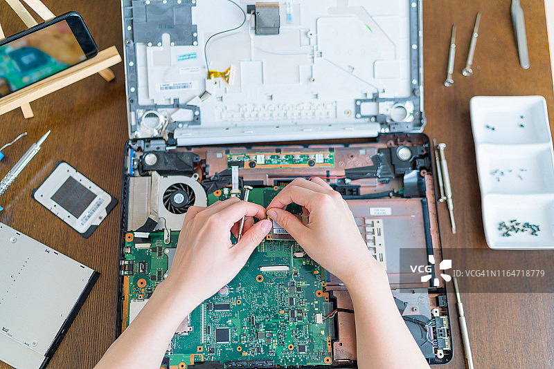 女人在家修理笔记本电脑的视角图片素材