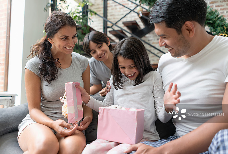 女儿和家人一起打开圣诞礼物图片素材