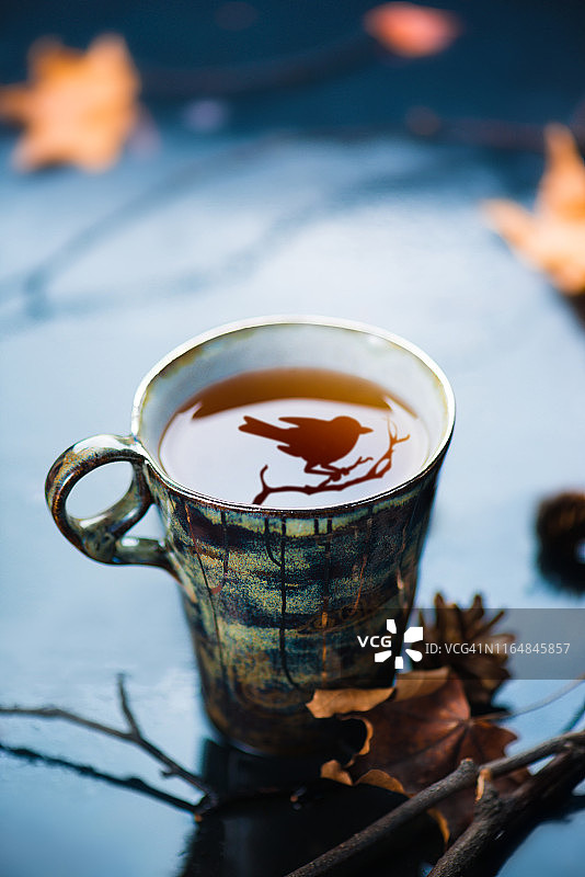森林茶会场景：手工陶瓷杯与黑鸟倒影，自然美食摄影图片素材